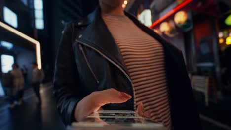 woman using smartphone in the city at night