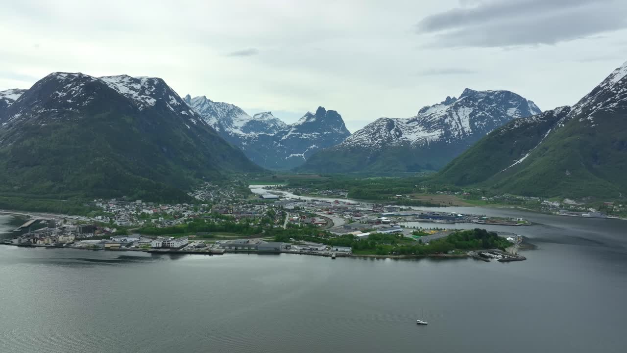andalsnes, noruega - vista aérea durante la primavera con bosques verdes y montañas cubiertas de nieve - rauma more y romsdal