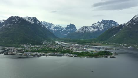 andalsnes norway - aerial view during spring with green forest and snow capped mountains - rauma more and romsdal