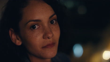 retrato de una hermosa mujer hispana en la azotea por la noche sonriendo feliz disfrutando de la vida nocturna urbana con luces de la ciudad bokeh en el fondo