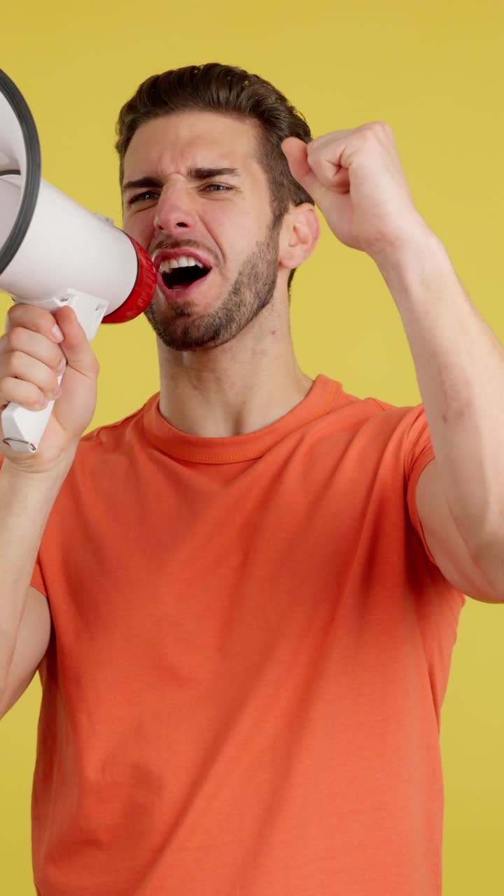 Man shouting into a megaphone with a raised fist