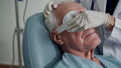 elderly patient receiving eye patch by doctor