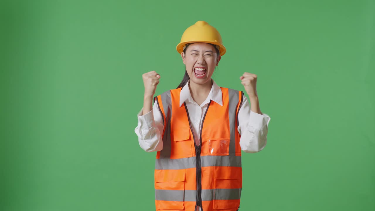 Asian Female Engineer With Safety Helmet Screaming Goal Celebrating Working In The Green Screen Background Studio