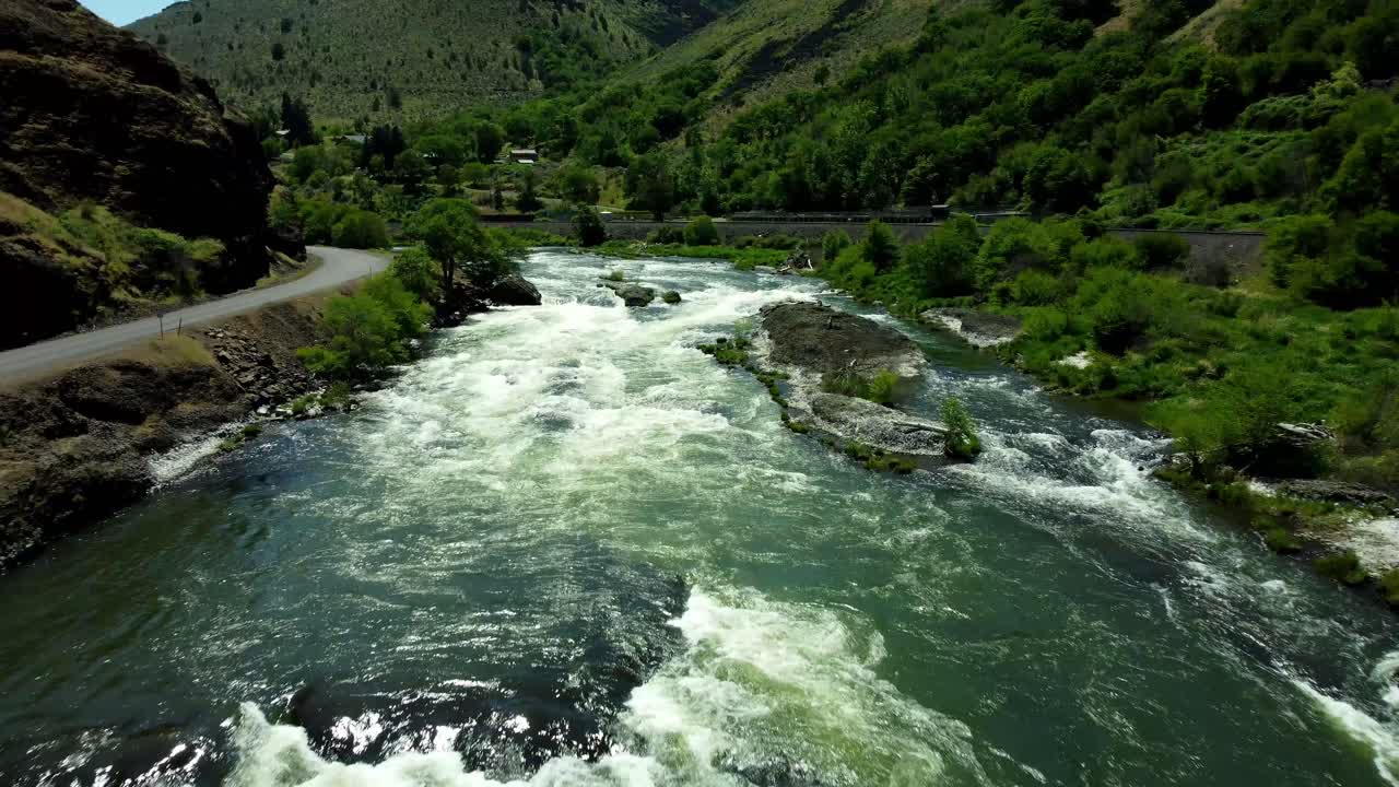 US, Oregon, Maupin, Baxter Rapids, 2025-05-08 - Drone view over the Deschutes River in Spring with a railroad line and green trees in north central Oregon