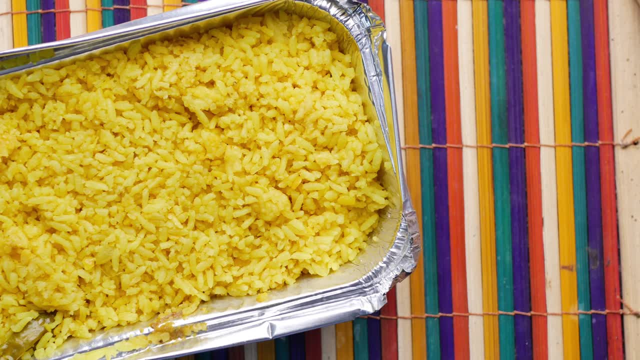 arroz amarillo en un recipiente de papel de aluminio
