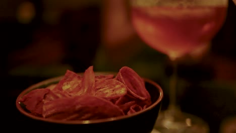 chips and cocktail in a dimly lit bar