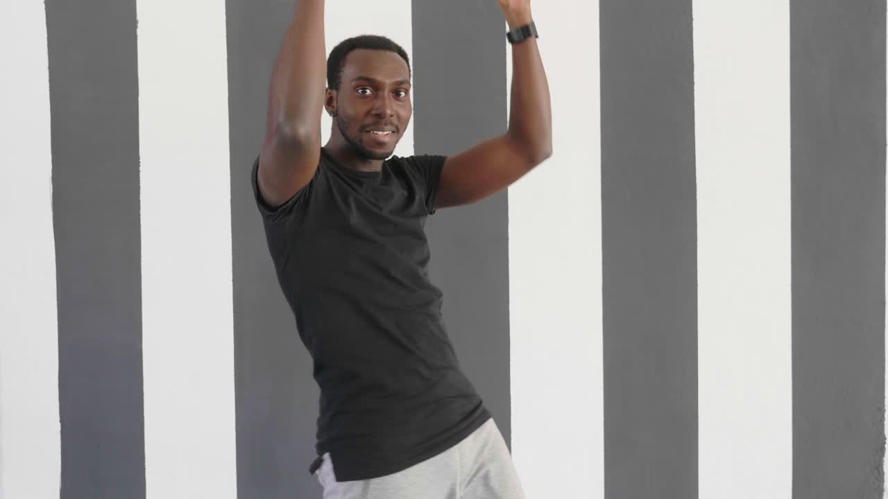 Man Dancing in Front of Striped Wall