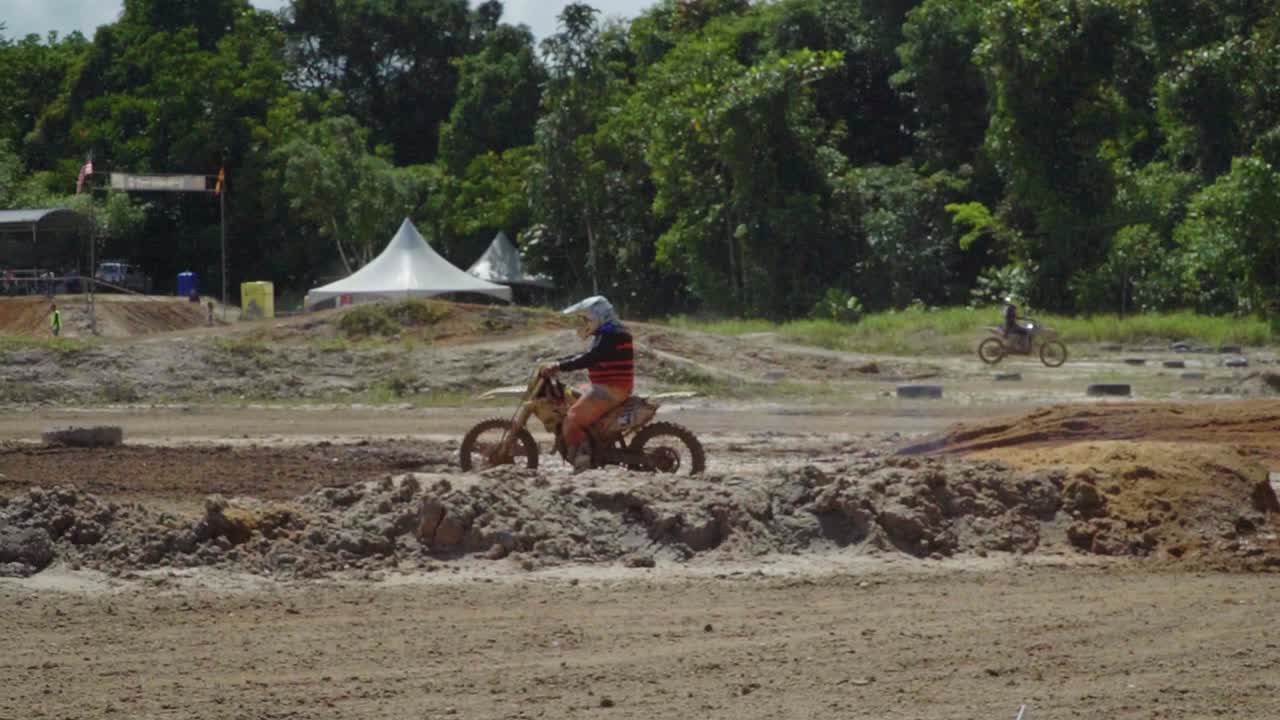 Woman Motocross Rider on a Muddy Track