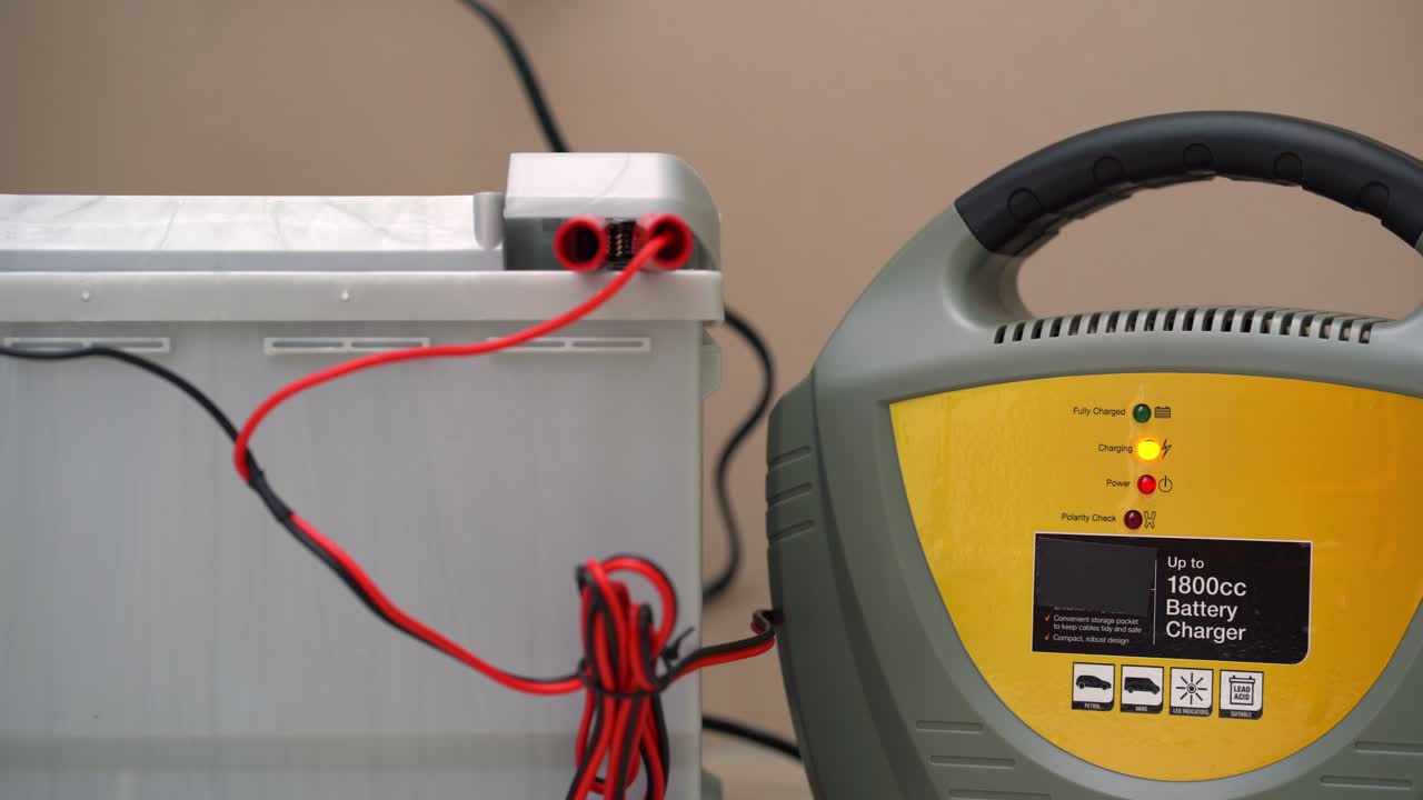 batería de automóvil cargada con cargador de red usando abrazaderas positivas y negativas