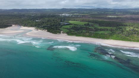 Largo-Tramo-De-Arena-En-La-Playa-De-Pertenencia-En-Byron-Bay,-Nueva-Gales-Del-Sur,-Australia---Toma-Aérea-De-Drones