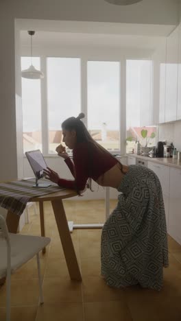 mujer trabajando desde casa en la cocina