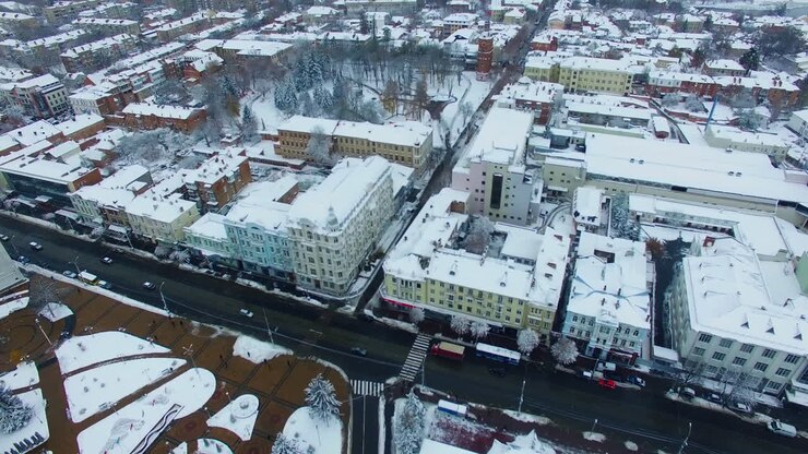 Snowy roofs of the buildings in the city downtown. Beautiful view of the urban landscape on winter day. Top view.