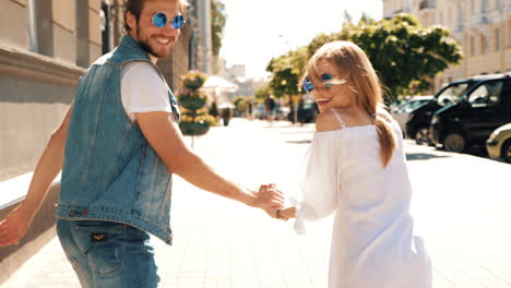 pareja caminando de la mano en la calle de la ciudad