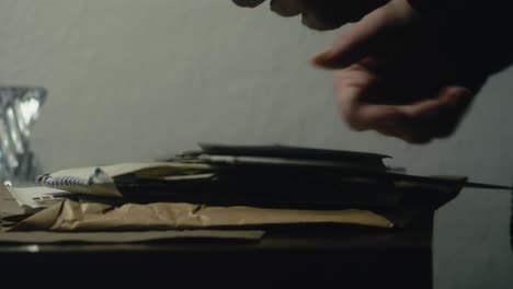 man finds private mail letter after searching old postal envelopes side shot