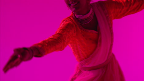 fotografía de estudio de una bailarina de kathak que realiza un baile vestida con el vestido tradicional indio contra un fondo púrpura 3