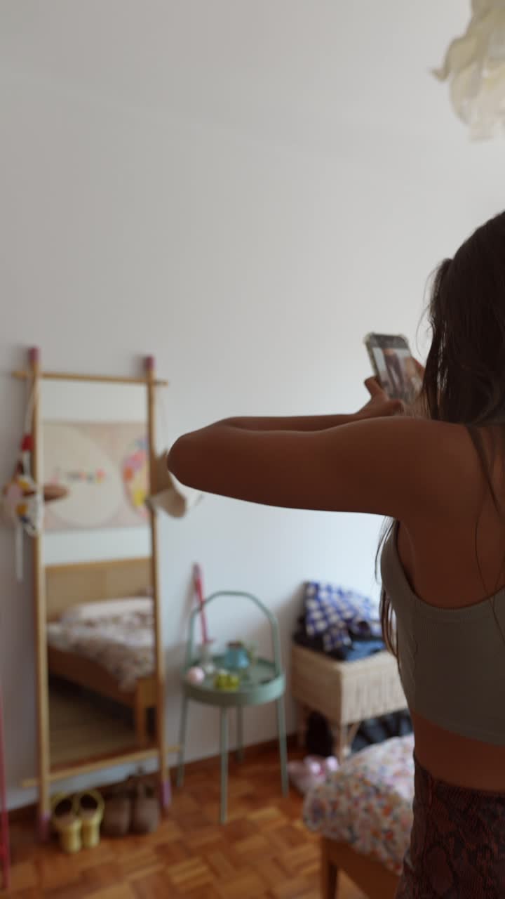 A woman is taking pictures of her in a bedroom