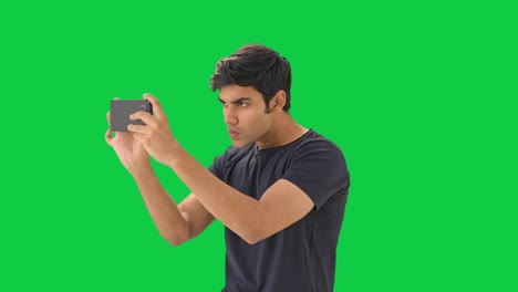 curious indian boy clicking pictures  green screen