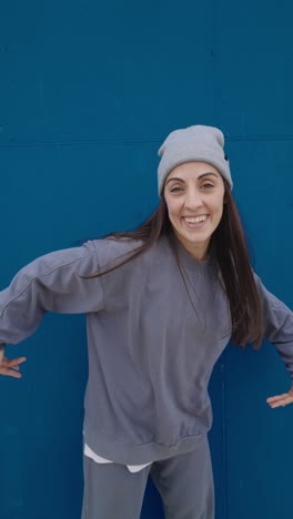 woman in casual wear posing in front of a blue background