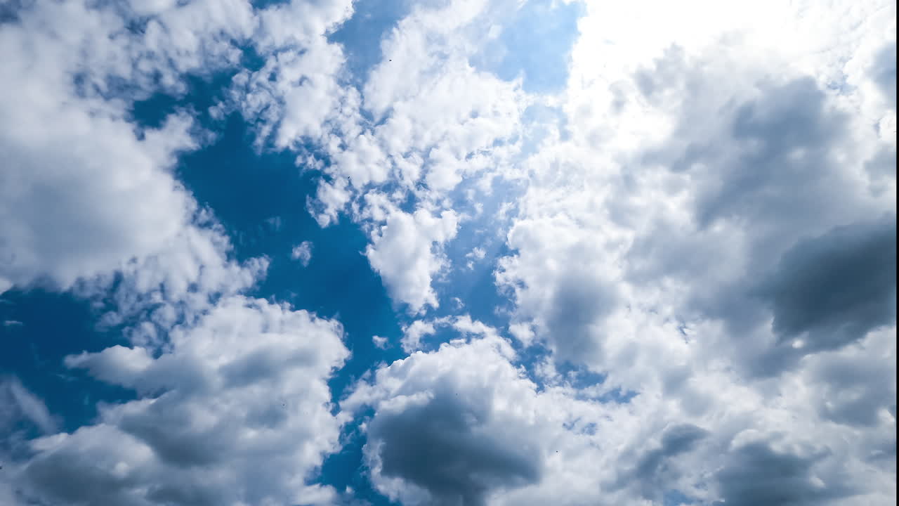 Lovely clouds gathering in the sky. Cloudscape transformation on summer sunny day in blue skies. Timelapse.
