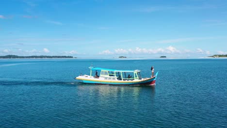 Antena-De-Una-Chica-Bronceada-Parada-En-La-Proa-Del-Barco-En-Un-Día-Soleado-De-Verano-En-Aguas-Tropicales-De-Belitung-Indonesia