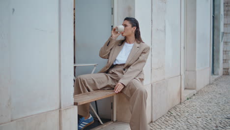 relaxed tourist drinking cappuccino in outdoors cafeteria. happy businesswoman