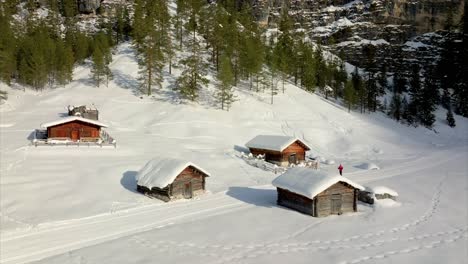 wooden cabins densely covered with snow in the village of san vigilio di marebbe, trentino-alto adige, italy