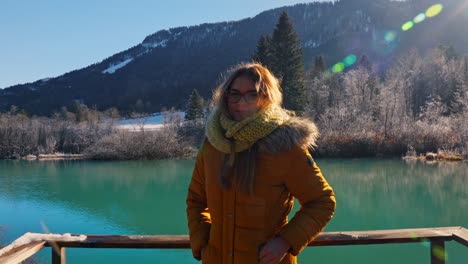 4k video of a happy young caucasian female standing near the lake in the natural reserve - zelenci, slovenia