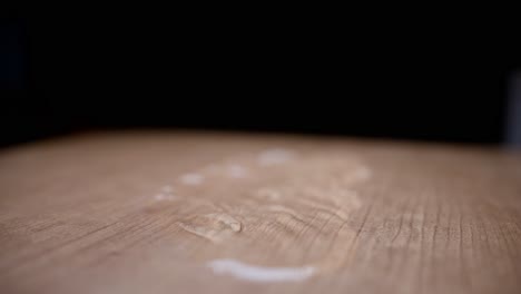 water droplets falling onto a wooden surface in super slow motion, with a blurred background