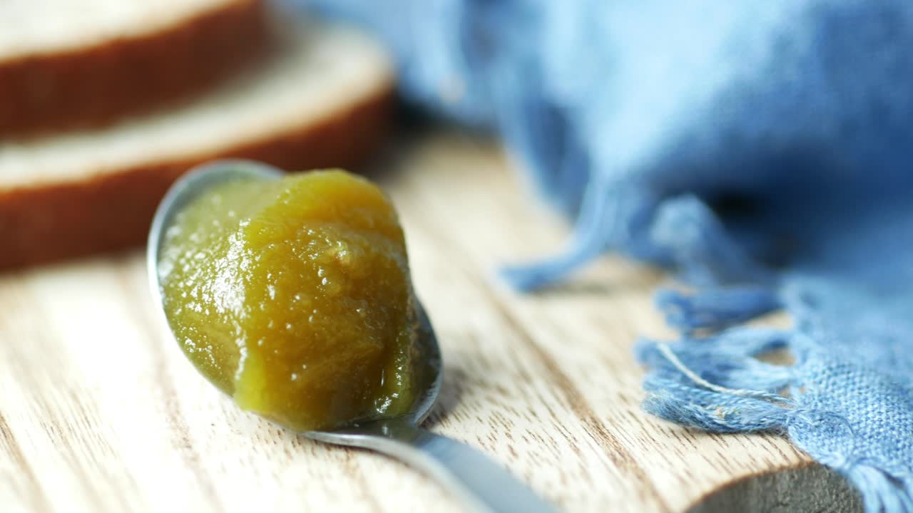 mermelada verde en una cuchara con pan