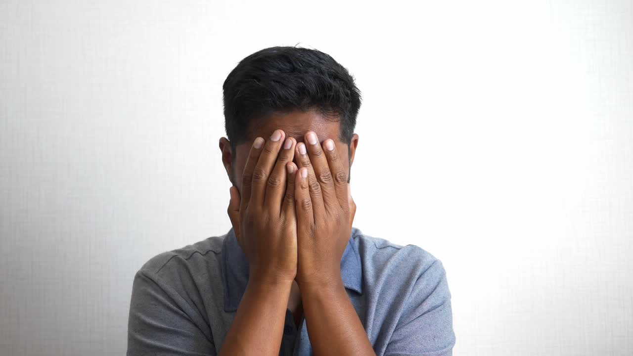 Uomo che si copre il viso