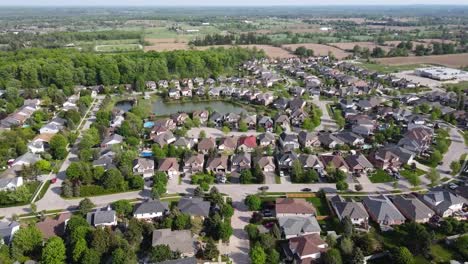 Toma-Aérea-Volando-Lejos-De-Un-Soleado-Suburbio-De-Guelph