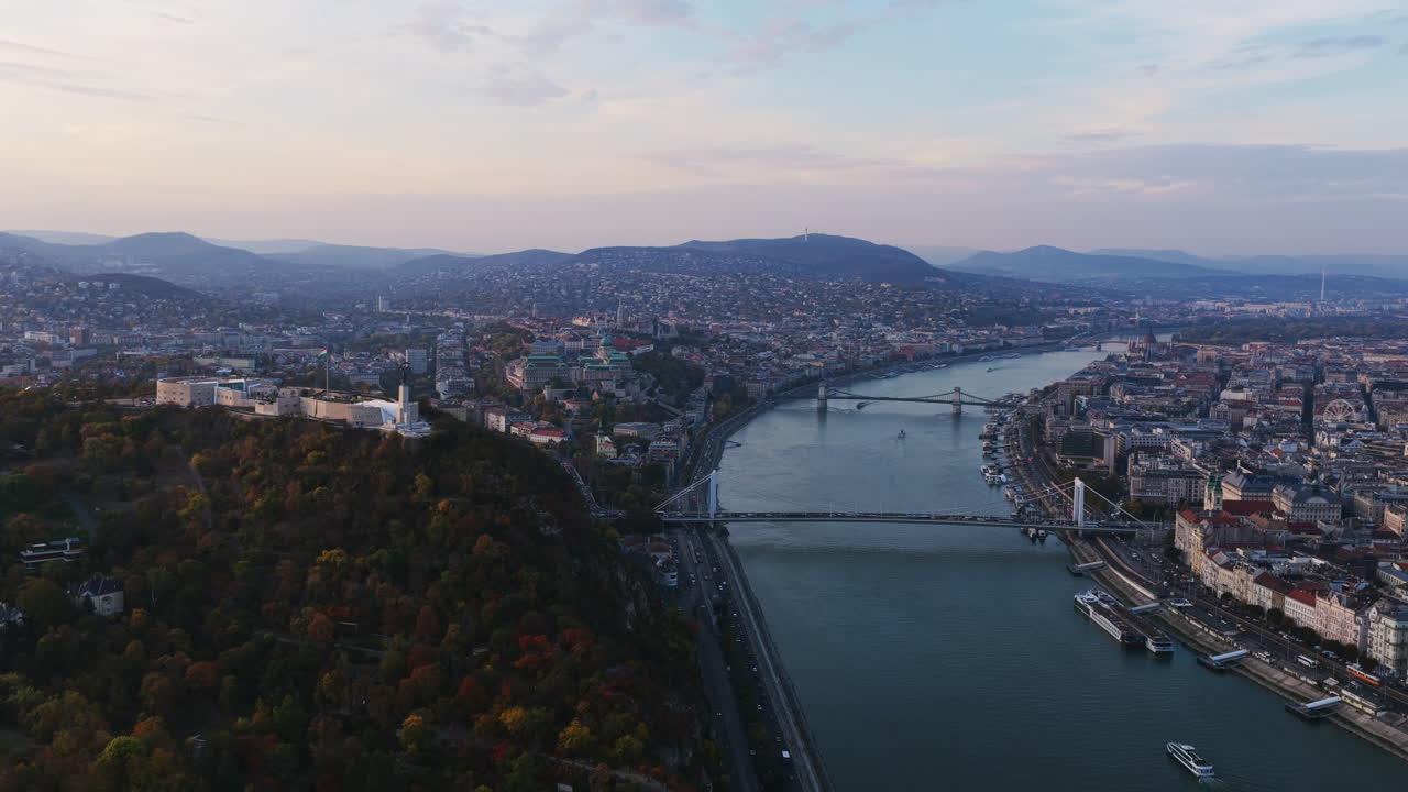 Dalla collina Gellért alla collina del castello, il Danubio collega gli intramontabili punti di riferimento di Budapest sotto un sereno cielo serale color pastello