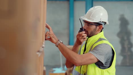 trabajador de carga profesional habla por radio portátil para comunicarse con otro trabajador