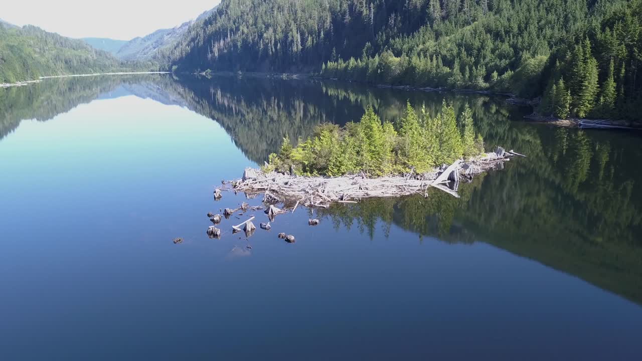 A small rugged island in a glassy mountain lake