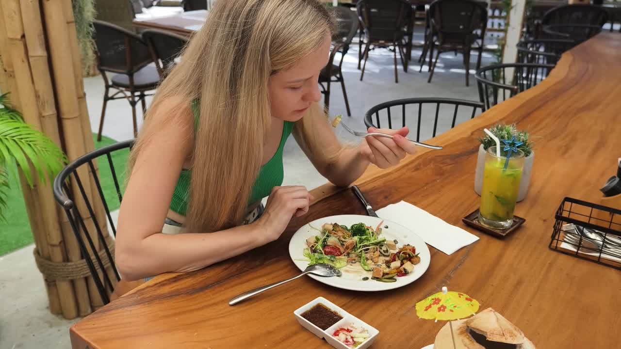 mujer comiendo ensalada al aire libre