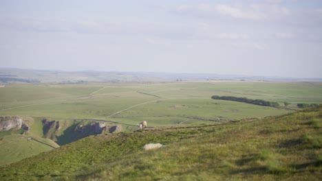 handheld shot of three sheep in distance on top of mam tor, castleton, peak district, england