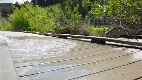 Man-Sieht,-Wie-Rauschendes-Flusswasser-über-Eine-Brücke-Fließt