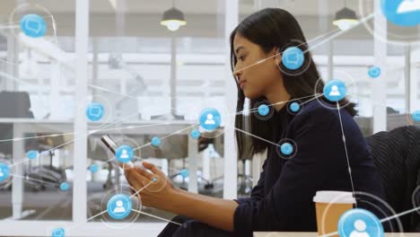 Animation-of-network-of-connections-with-icons-over-biracial-businesswoman-using-smartphone