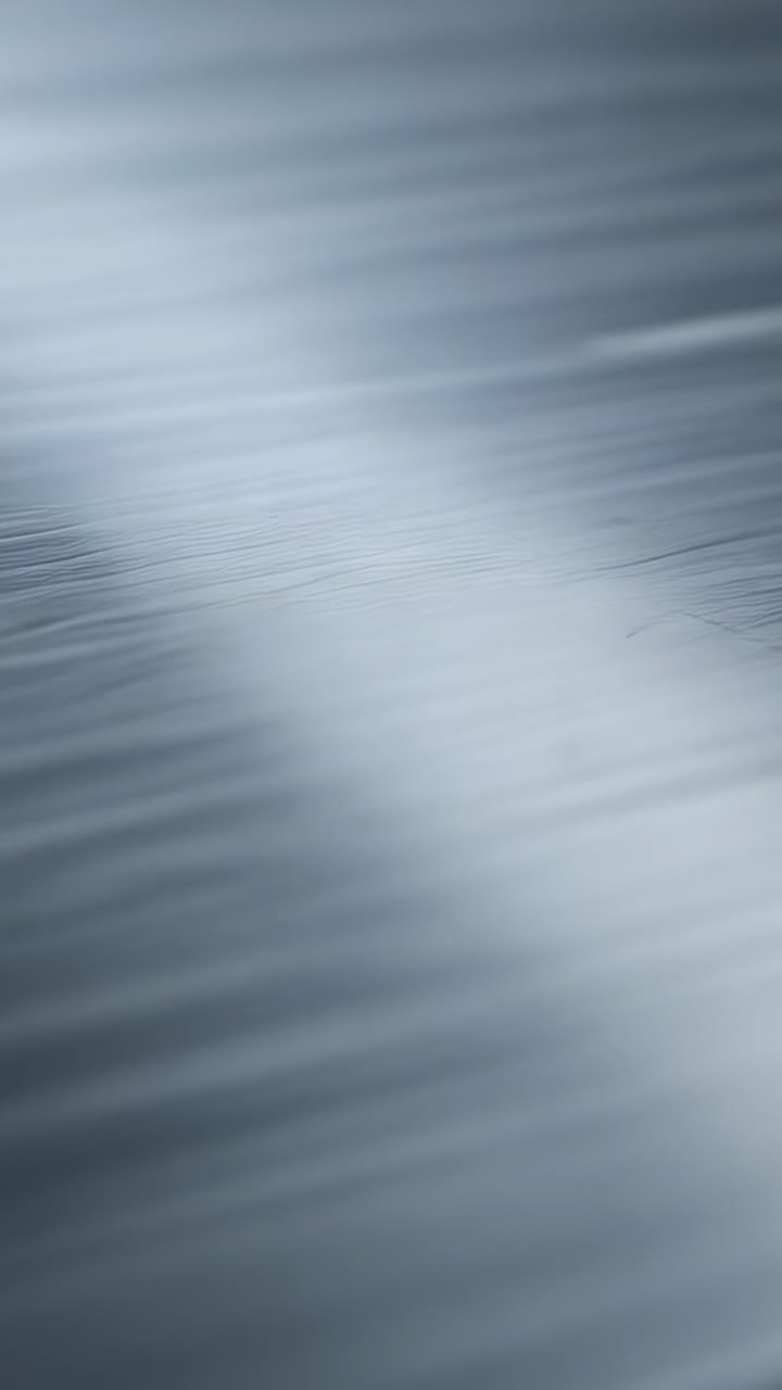 Vertical video: Shifting camera slightly across tabletop to reveal seam, grain, and diagonal light