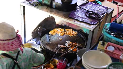 vendor prepares crispy mussel pancakes in bangkok