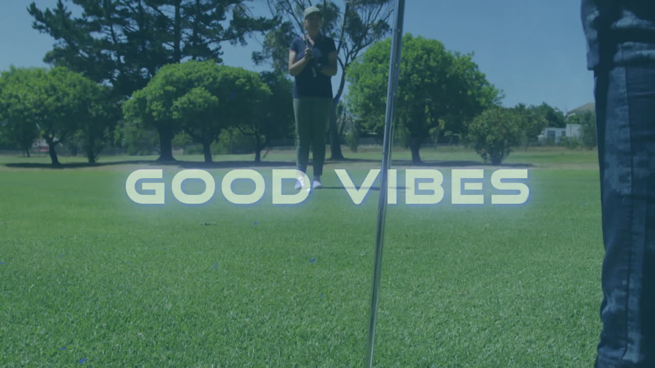 Foreground golfer placing wedge on manicured sports green, animated overlay showing GOOD VIBES text