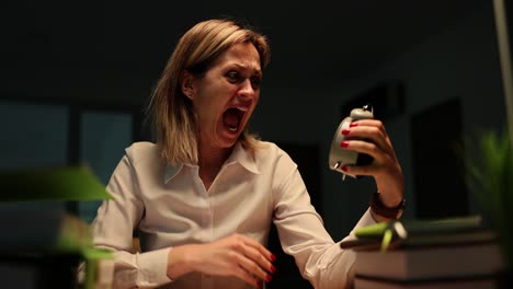 stressed woman screaming at alarm clock working late