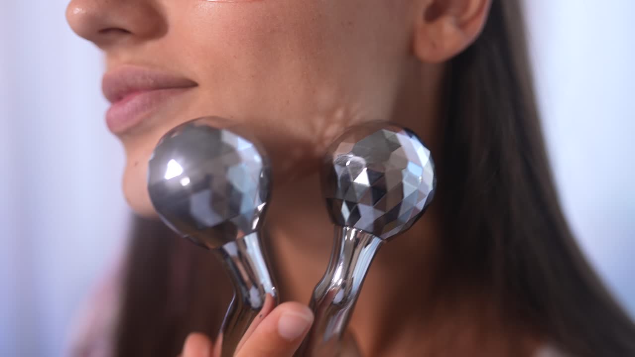 피부 관리용 얼굴 마사지를 사용하는 여성