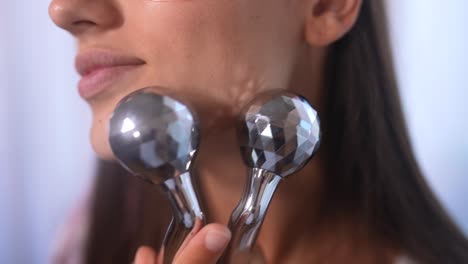 mujer que usa masajeador facial para el cuidado de la piel