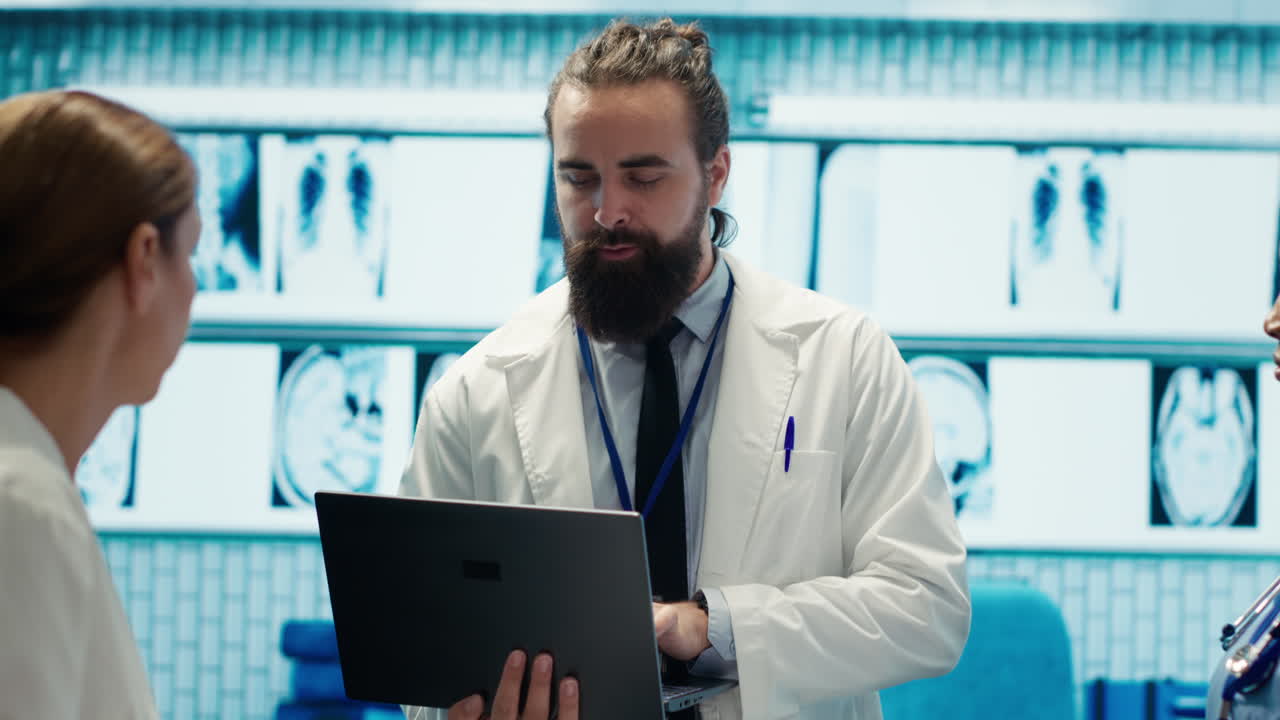 Medical professionals discussing x-rays using a laptop