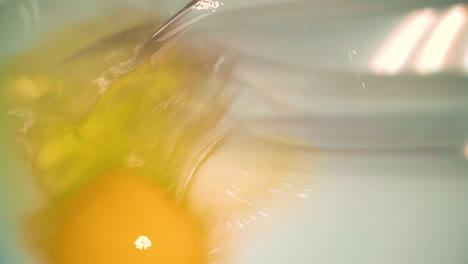 beating egg with whisk in white ceramic bowl closeup