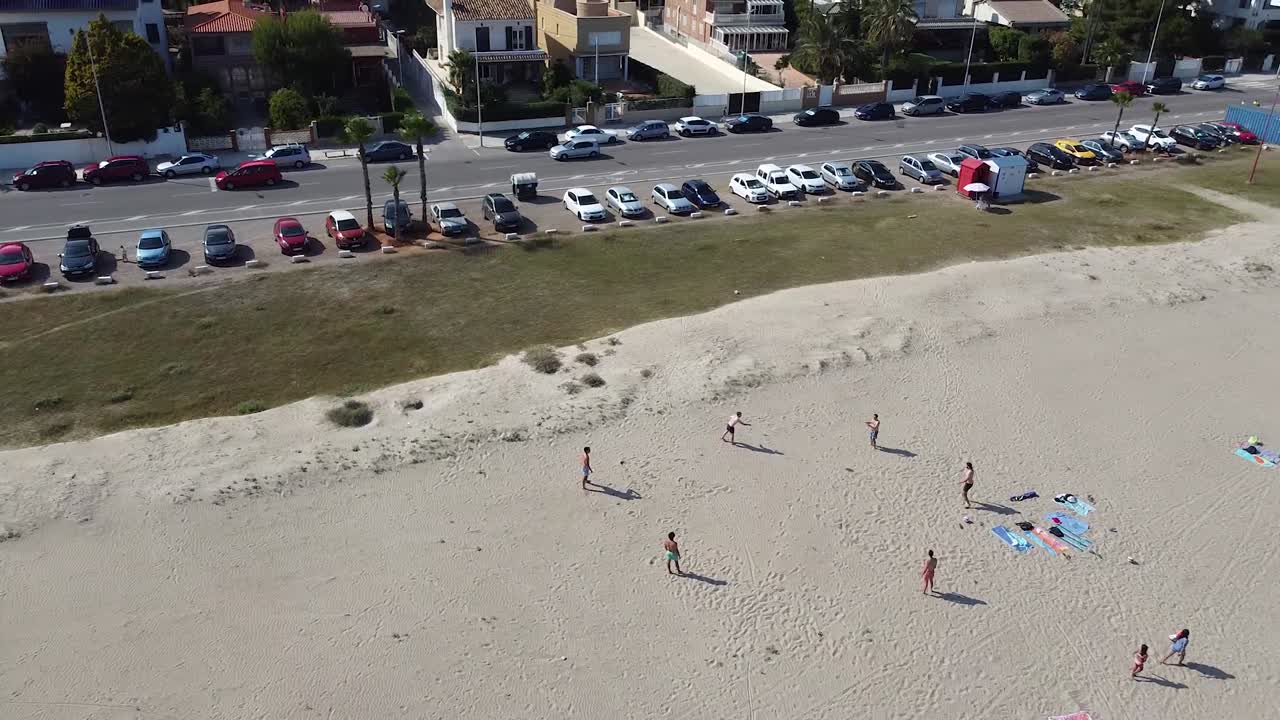 grupo de amigos jugando frisbie en una playa en españa