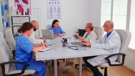 enfermera joven explicando el diagnóstico al personal médico