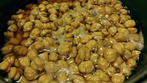 overhead close up of a pot of chickpeas in boiling water in preparation for making healthy falafels, candid home life moments