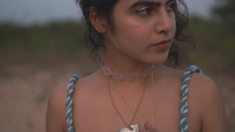 female model showing off her necklace and looking around